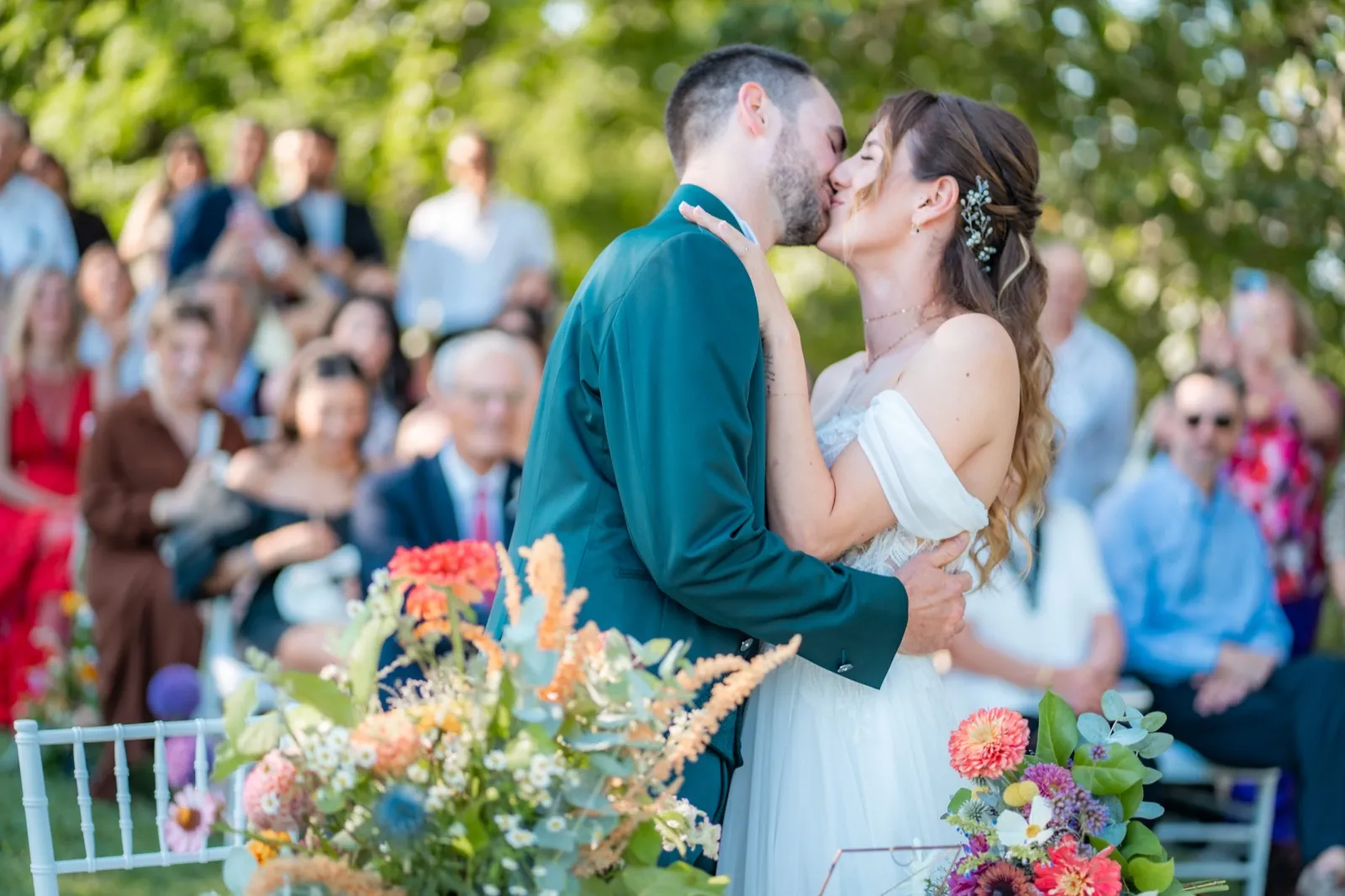 Il bacio degli sposi a una cerimonia all'aperto, tra gli invitati