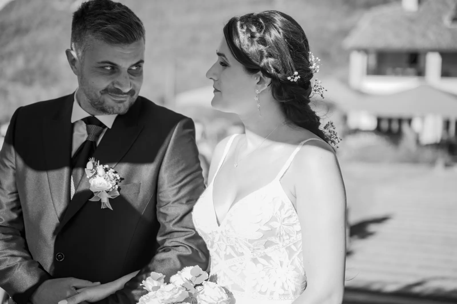 Ritratto in bianco e nero degli sposi: lui sorride di sbieco e la guarda, lei lo guarda di profilo, con la treccia e i fiorellini tra i capelli